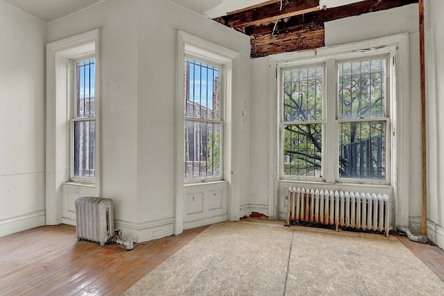 doorway featuring wood-type flooring, plenty of natural light, and radiator heating unit