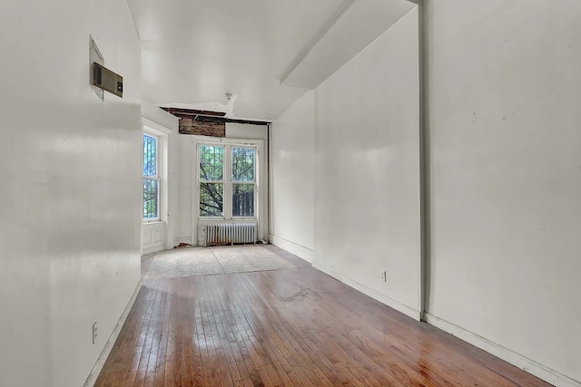 spare room with hardwood / wood-style flooring, baseboards, and radiator