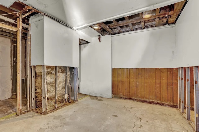 unfinished below grade area featuring wood walls and wainscoting