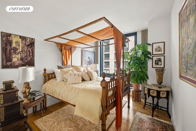 bedroom featuring expansive windows, wood finished floors, and visible vents