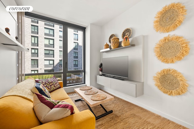 sitting room featuring carpet, baseboards, and a wall of windows