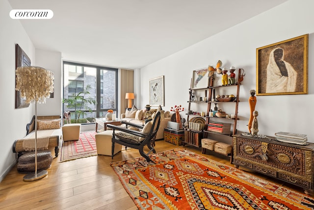 living room featuring visible vents, a wall of windows, and light wood-style flooring