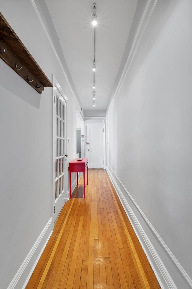 hall with light wood-type flooring and baseboards