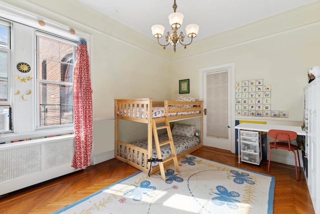 bedroom featuring radiator heating unit, multiple windows, and a chandelier