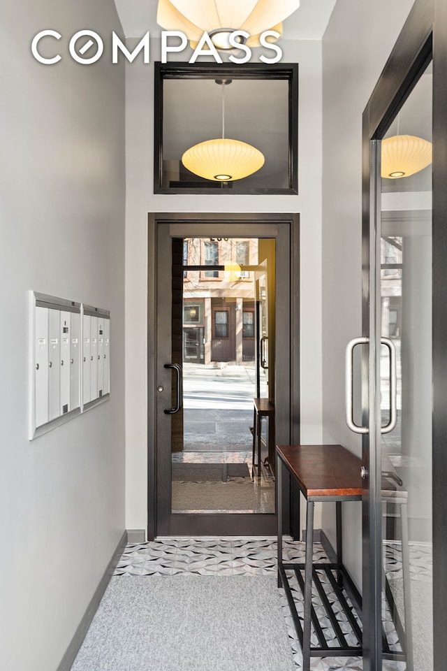 interior space featuring mail area, baseboards, and carpet flooring