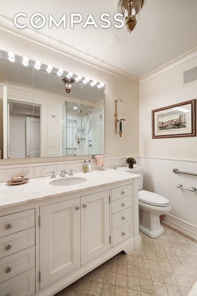 full bathroom with visible vents, ornamental molding, a stall shower, wainscoting, and vanity