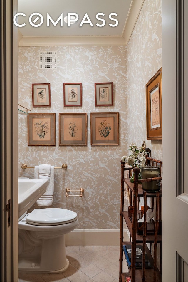 half bathroom with visible vents, wallpapered walls, toilet, baseboards, and tile patterned floors