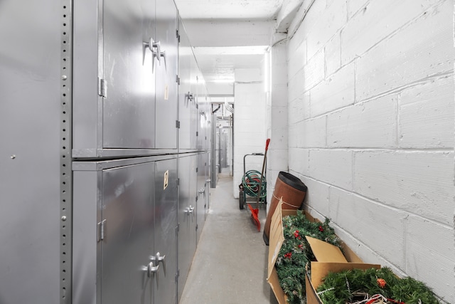 hallway with concrete flooring and concrete block wall