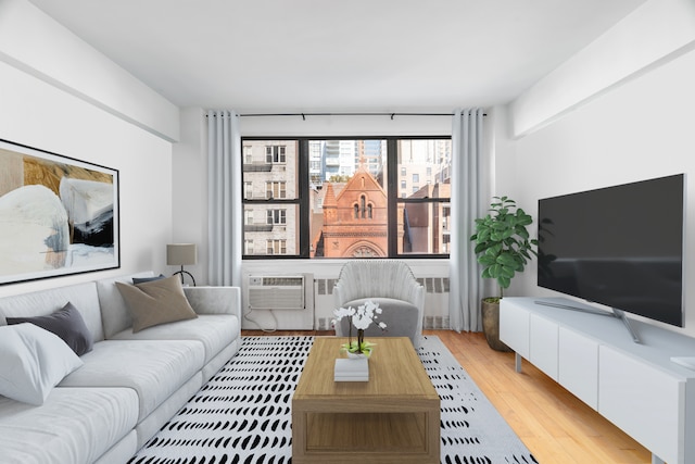 living room with light wood-style flooring, radiator heating unit, and a wall mounted AC