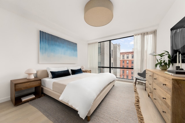 bedroom featuring light wood-style floors and baseboards