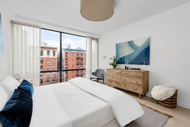 75 1st Ave Unit 5D, New York City, NY 10003 - bedroom featuring multiple windows, wood finished floors, and a wall of windows