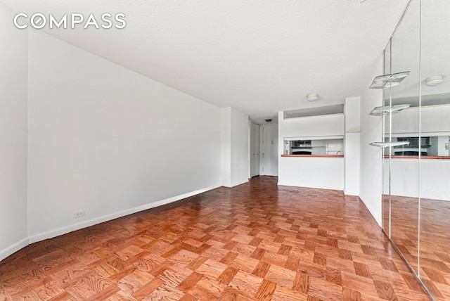 unfurnished living room featuring baseboards