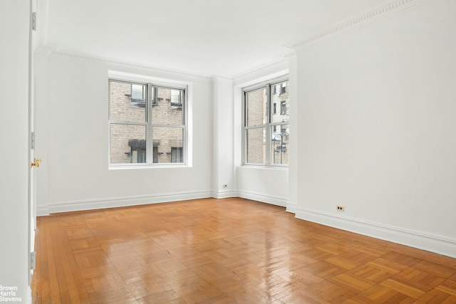 unfurnished room featuring plenty of natural light, baseboards, and crown molding