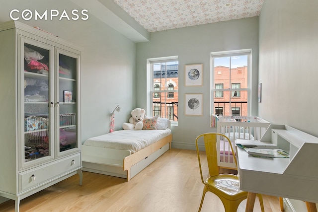 bedroom featuring baseboards and wood finished floors