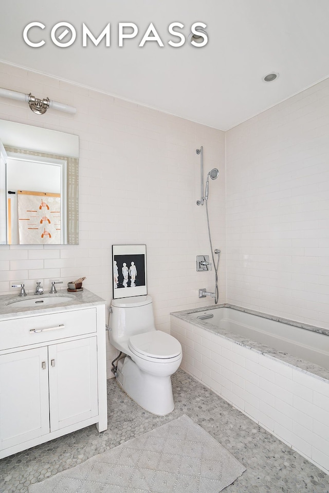 bathroom featuring toilet, tiled shower / bath combo, tile walls, and vanity