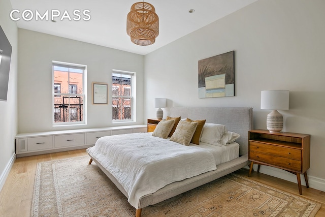 bedroom featuring light wood-style floors and baseboards