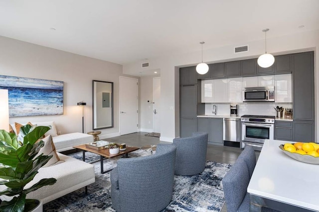 living area with baseboards and visible vents