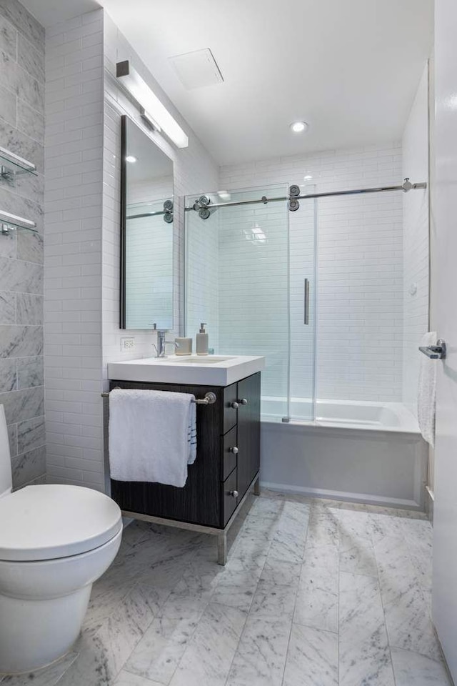 bathroom with marble finish floor, shower / bath combination with glass door, vanity, and toilet