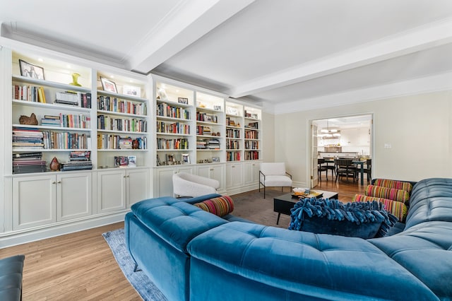 living area with beamed ceiling, light wood-type flooring, and crown molding