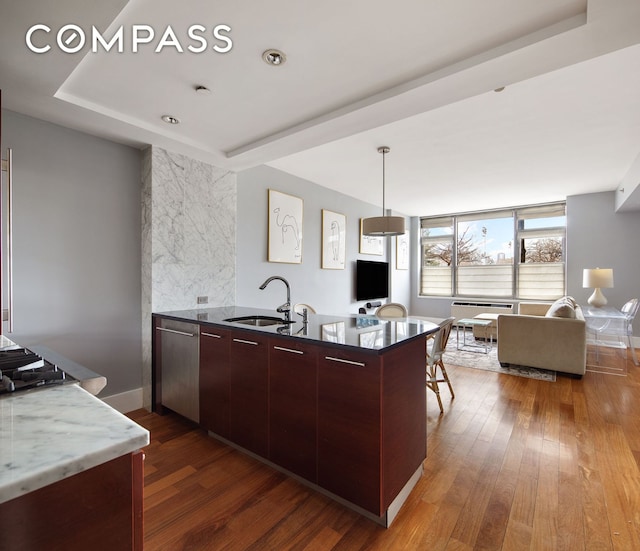 kitchen featuring dark wood-type flooring, open floor plan, a sink, and stainless steel dishwasher