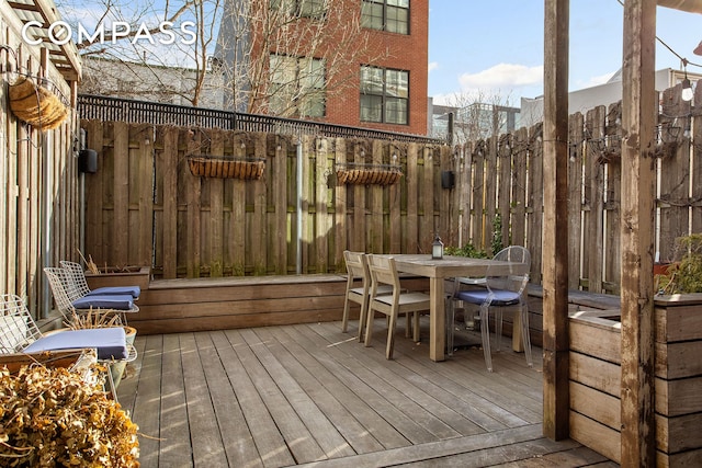 wooden terrace with fence and outdoor dining area