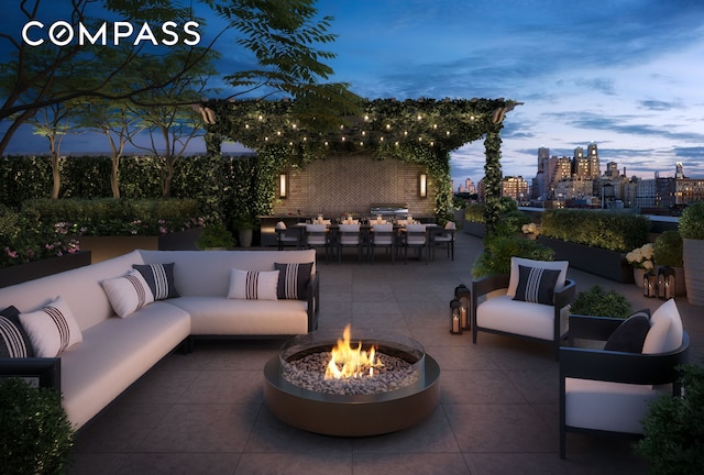 patio terrace at dusk with outdoor dining space, a city view, and an outdoor living space with a fire pit