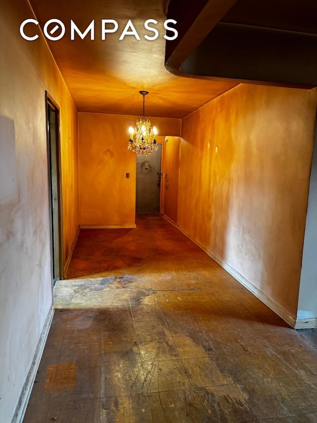 unfurnished dining area with baseboards and a notable chandelier