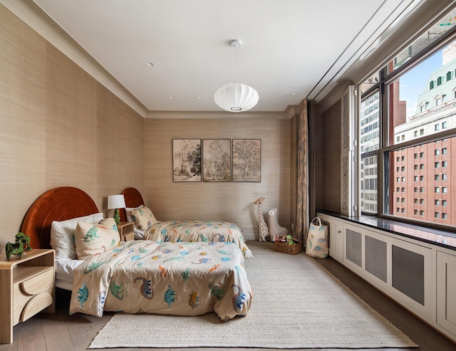 bedroom featuring wallpapered walls and a city view