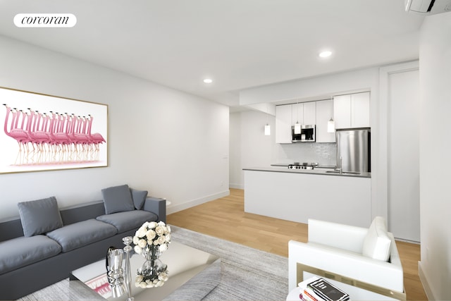 living room with baseboards, light wood finished floors, visible vents, and recessed lighting