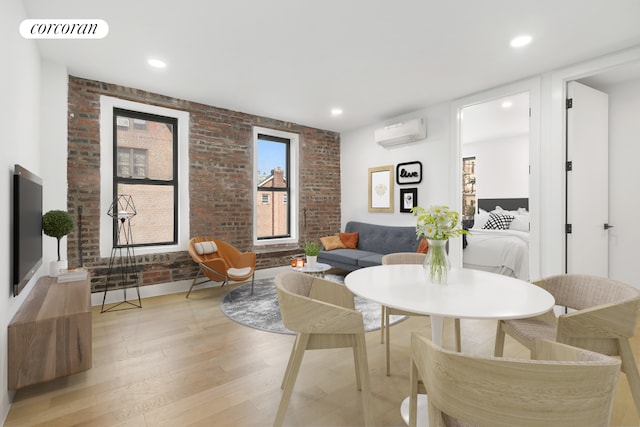 living area with visible vents, brick wall, a wall mounted air conditioner, light wood-style floors, and recessed lighting