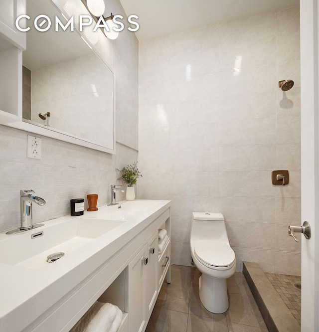 bathroom with tile walls, toilet, tiled shower, vanity, and backsplash