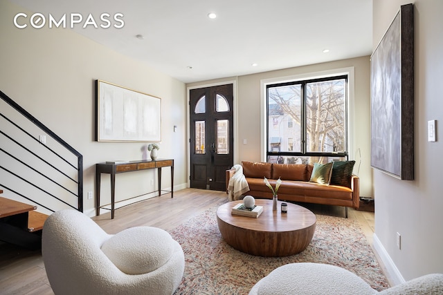 living area featuring stairs, wood finished floors, baseboards, and recessed lighting