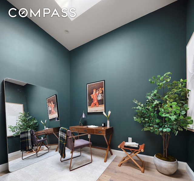 home office featuring wood finished floors, high vaulted ceiling, and baseboards