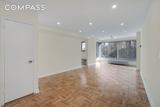 empty room with recessed lighting, a baseboard heating unit, and baseboards