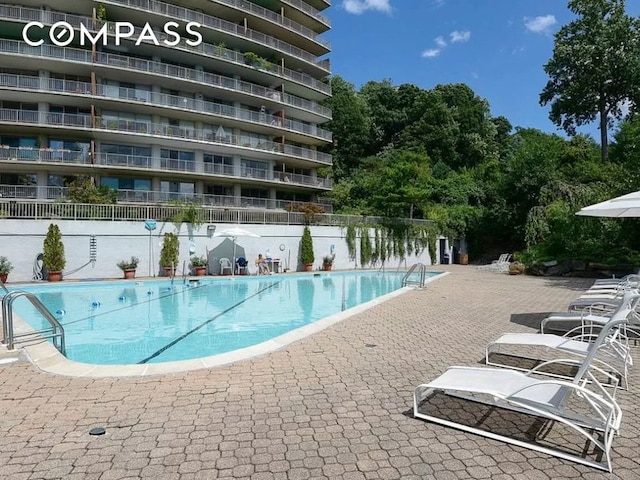 community pool featuring a patio and fence