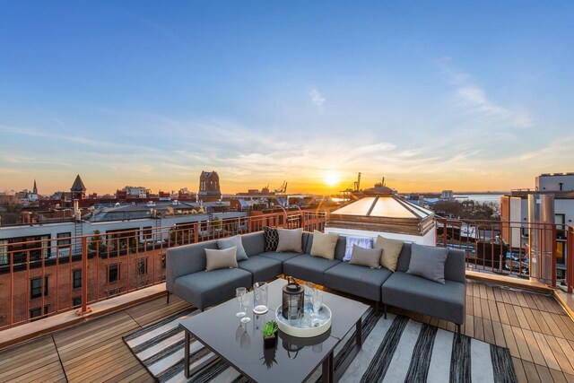 patio terrace at dusk with a balcony and a view of city