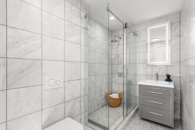 full bathroom featuring toilet, vanity, a shower stall, and tile walls