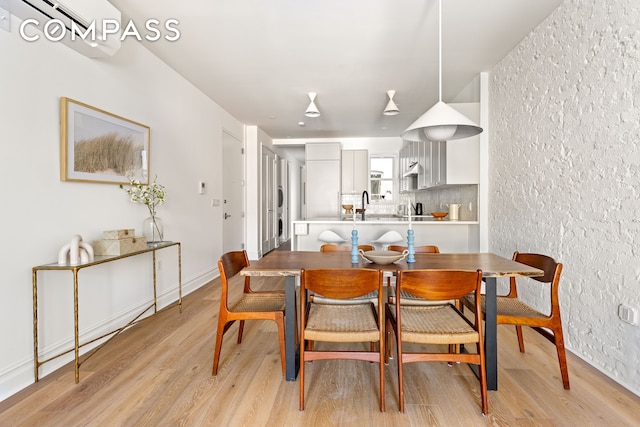 dining area featuring light wood-type flooring and baseboards