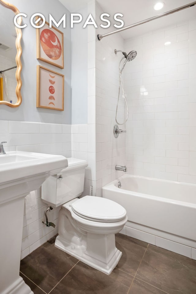 full bath featuring visible vents, toilet, tile patterned flooring, shower / bathtub combination, and tile walls