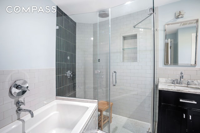 full bath with vanity, tile walls, a bath, tile patterned floors, and a stall shower