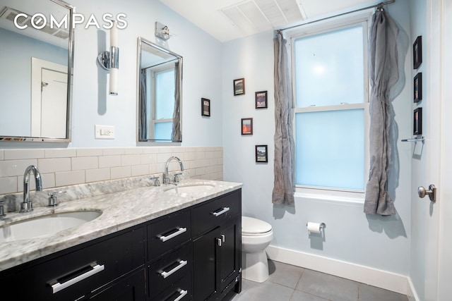 full bath with tile patterned flooring, toilet, baseboards, and double vanity