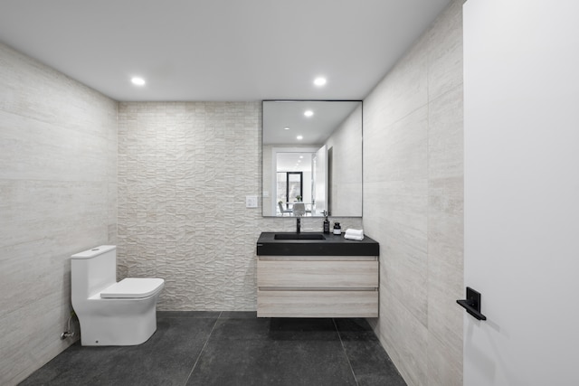 bathroom featuring recessed lighting, toilet, tile walls, and vanity