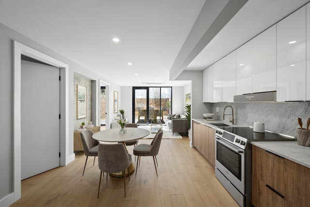 kitchen with stainless steel electric range oven, modern cabinets, white cabinets, and a sink