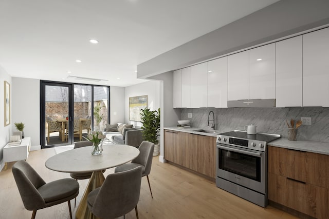 kitchen with brown cabinets, light countertops, electric range, white cabinetry, and modern cabinets