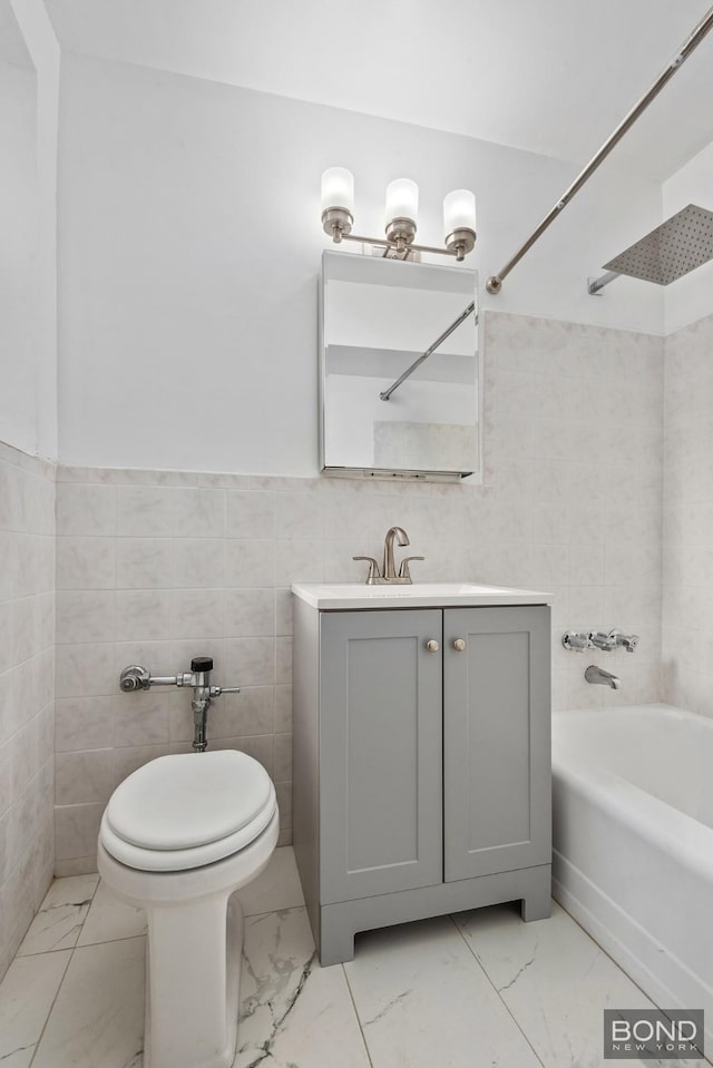bathroom with marble finish floor, tile walls, toilet, shower / bathtub combination, and vanity
