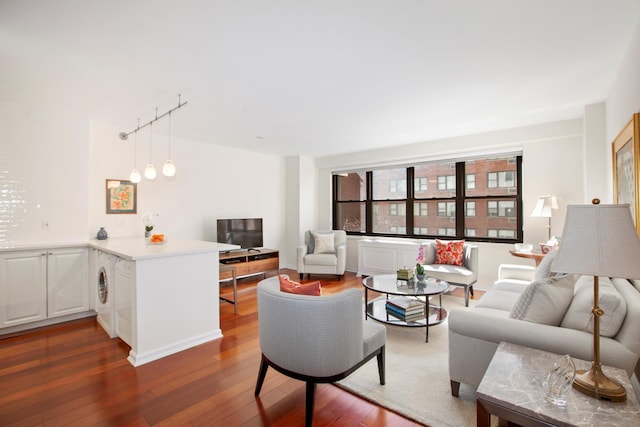 living area featuring dark wood-type flooring and washer / dryer