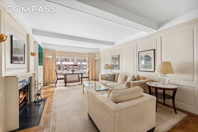 living room featuring a decorative wall, beamed ceiling, and a high end fireplace