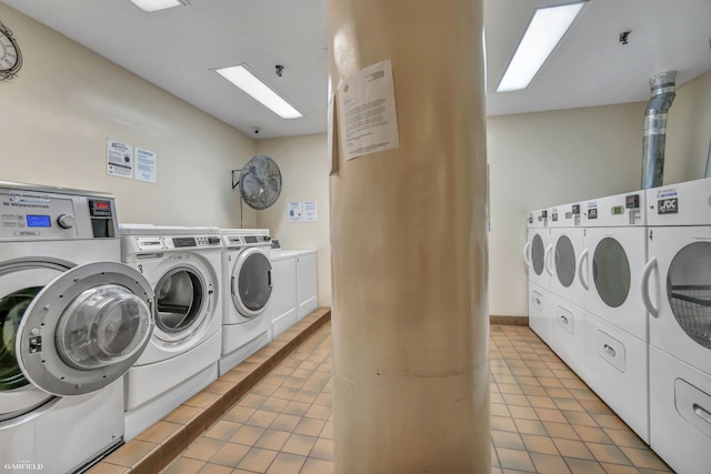 community laundry room featuring washer and clothes dryer and light tile patterned floors