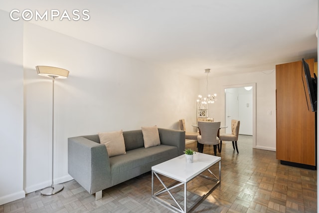 living area with a notable chandelier and baseboards