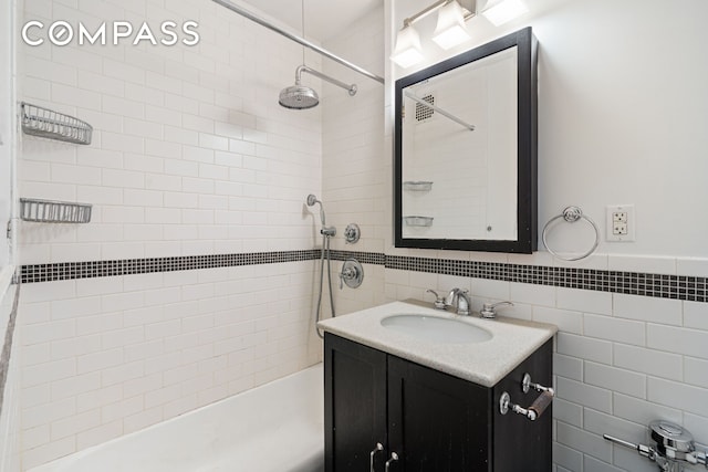 full bathroom featuring tile walls, vanity, and bathing tub / shower combination